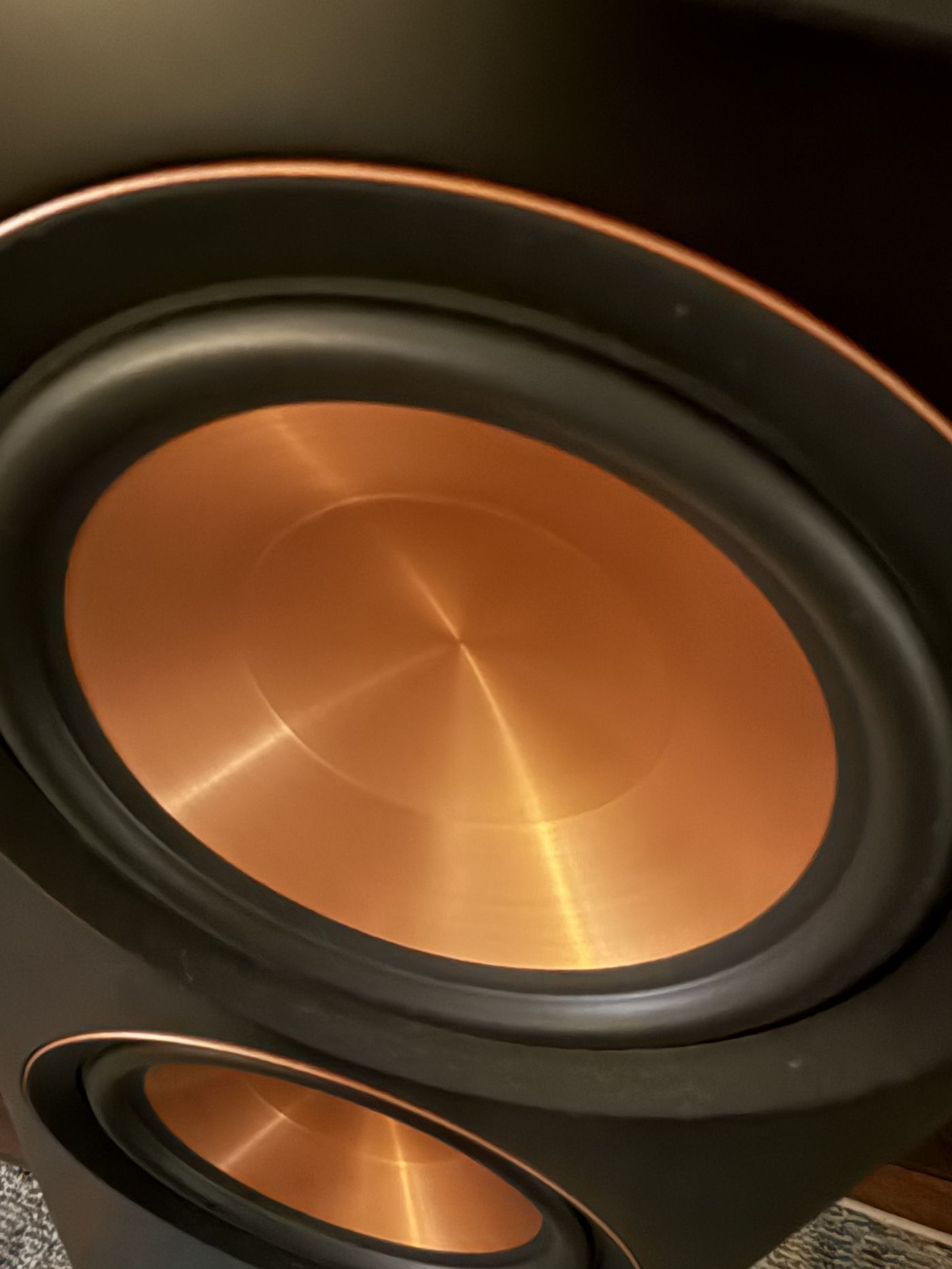 Close-up of a copper speaker cone in warm light